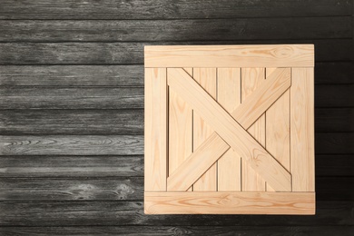 Photo of Wooden crate on dark background, top view with space for text