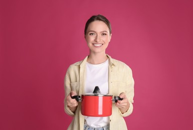 Happy woman with pot on crimson background