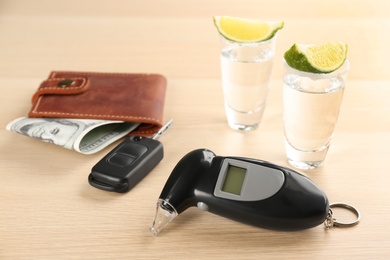 Composition with modern breathalyzer on wooden table