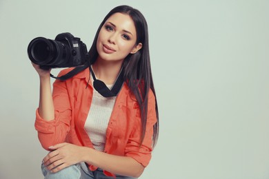 Professional photographer with camera on light background