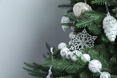 Photo of Beautiful Christmas tree with decor on light grey background, closeup. Space for text