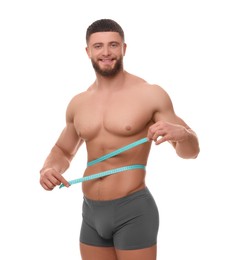 Photo of Portraithappy athletic man measuring waist with tape on white background. Weight loss concept