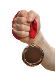 Man holding golden medal on white background, closeup. Space for design