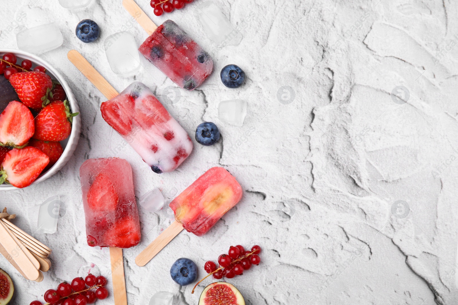 Photo of Flat lay composition with fruit and berry ice pops on light table. Space for text