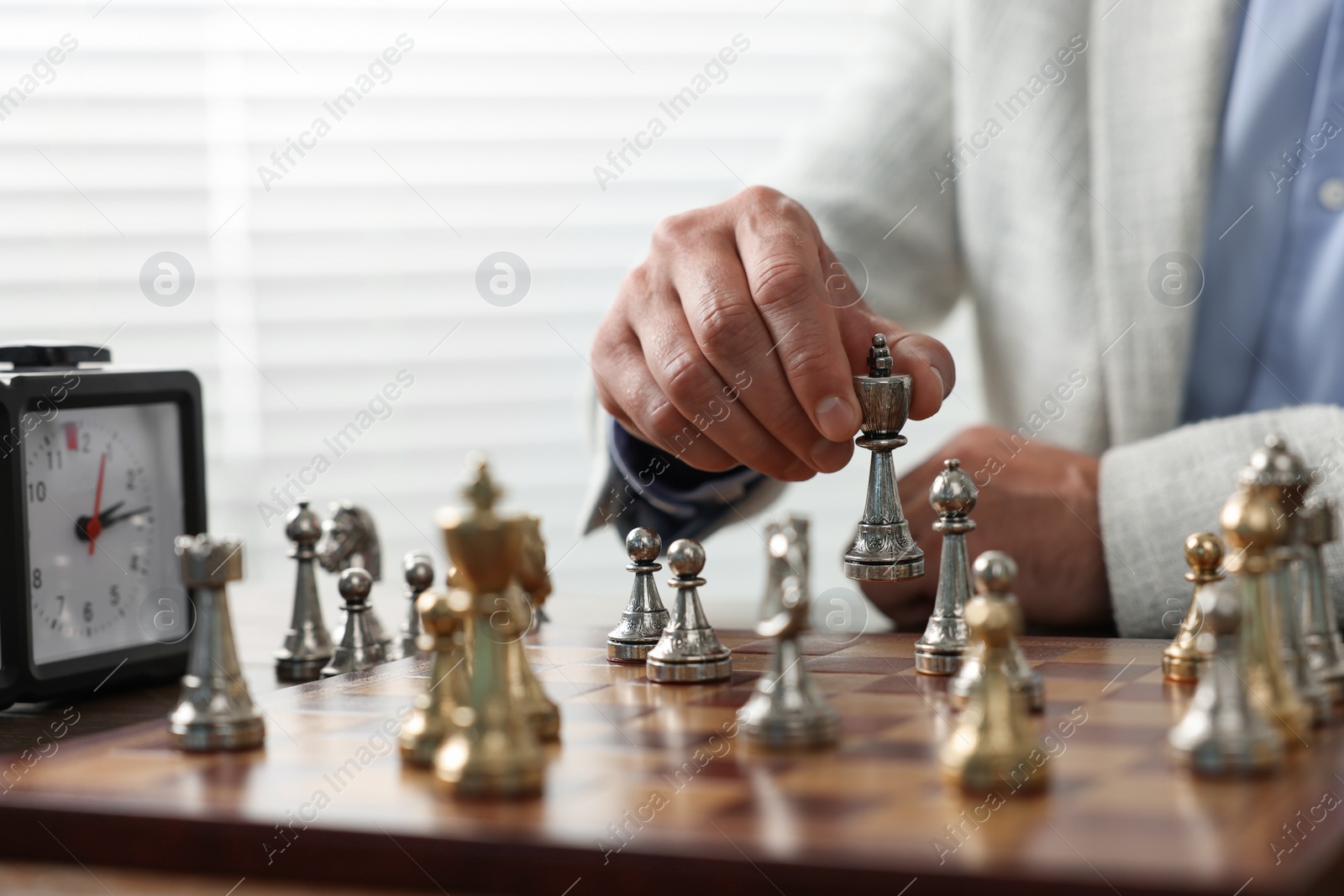 Photo of Man playing chess during tournament at chessboard, closeup