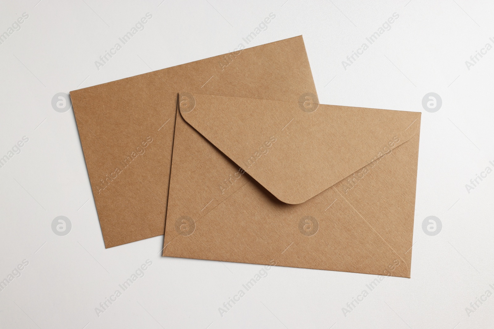 Photo of Envelopes made of parchment paper on white background, flat lay