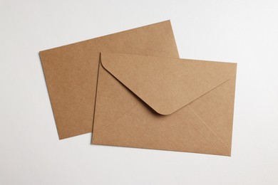 Envelopes made of parchment paper on white background, flat lay