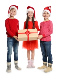 Photo of Cute little children in Santa hats with Christmas gift box on white background