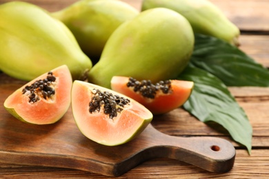 Fresh ripe papaya fruits on wooden table