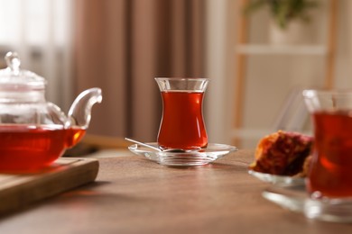 Photo of Glasses with traditional Turkish tea on wooden table