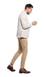 Man using smartphone while walking on white background