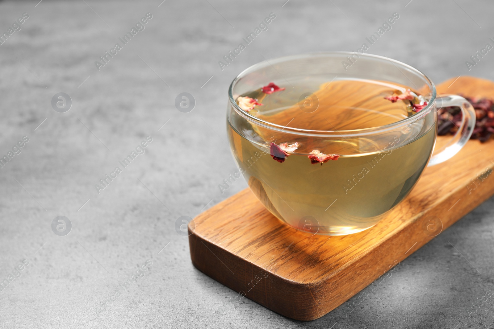 Photo of Cup of green tea with dry flowers on grey table. Space for text