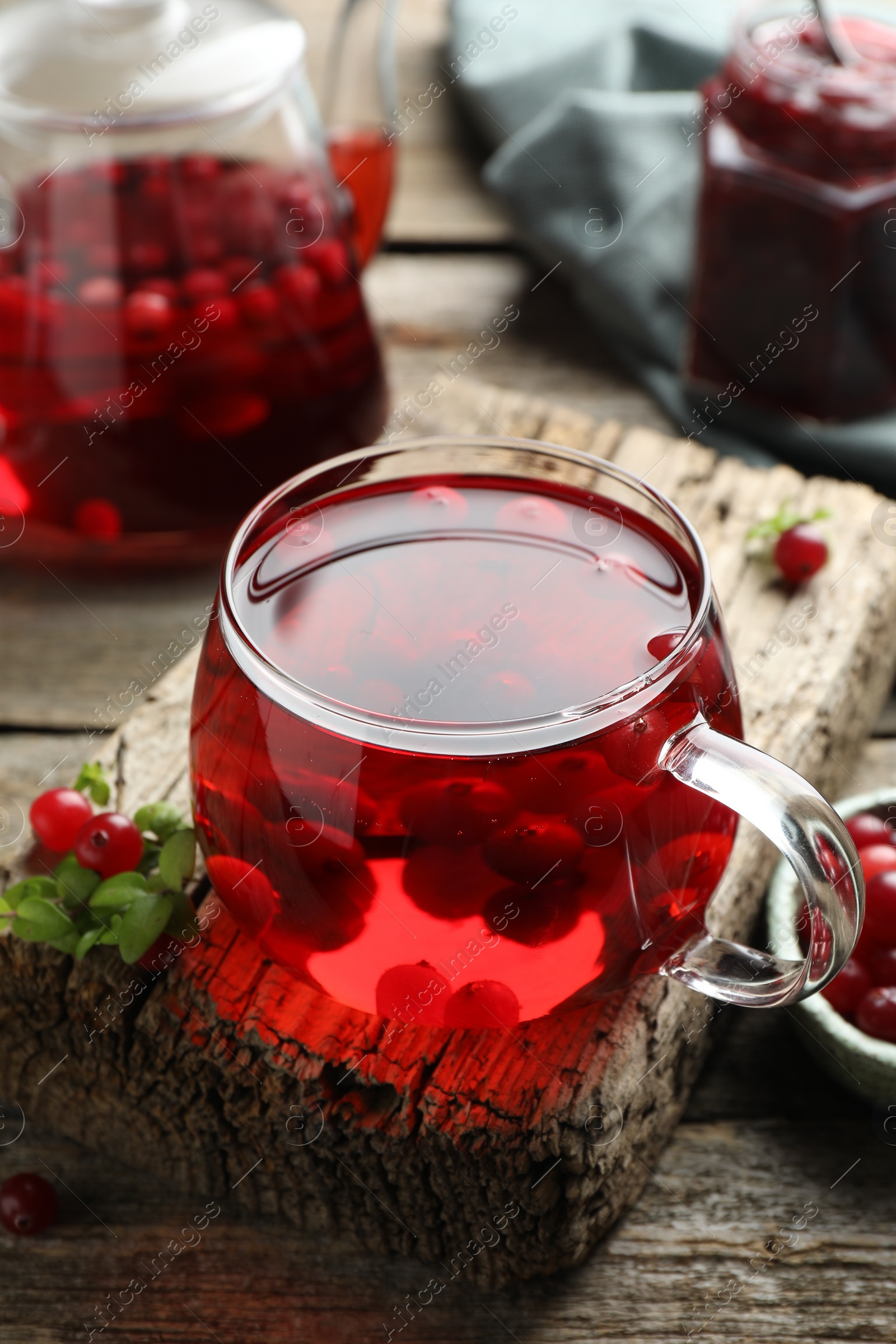 Photo of Delicious cranberry tea and berries on wooden table, closeup