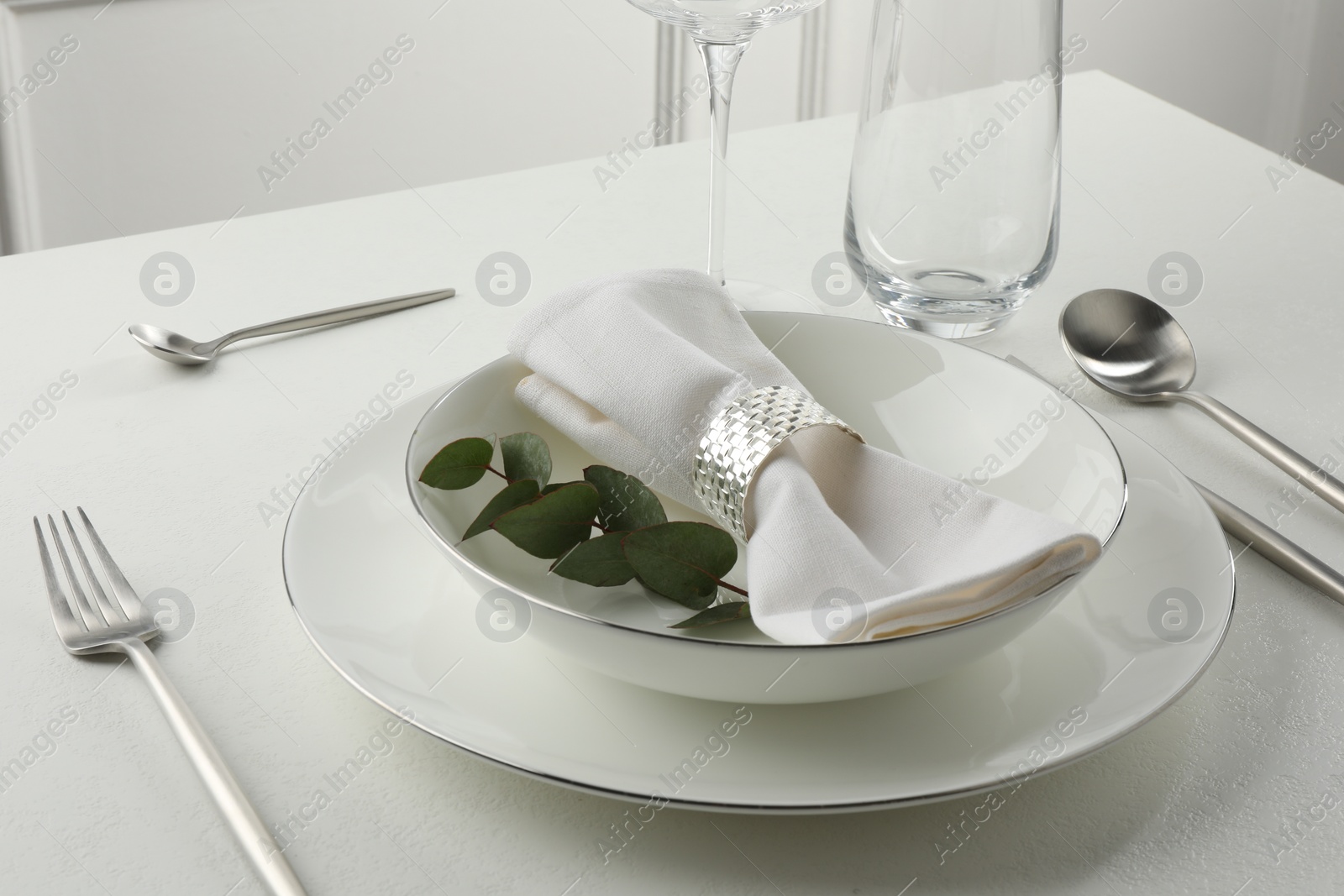 Photo of Stylish setting with cutlery and napkin on white textured table