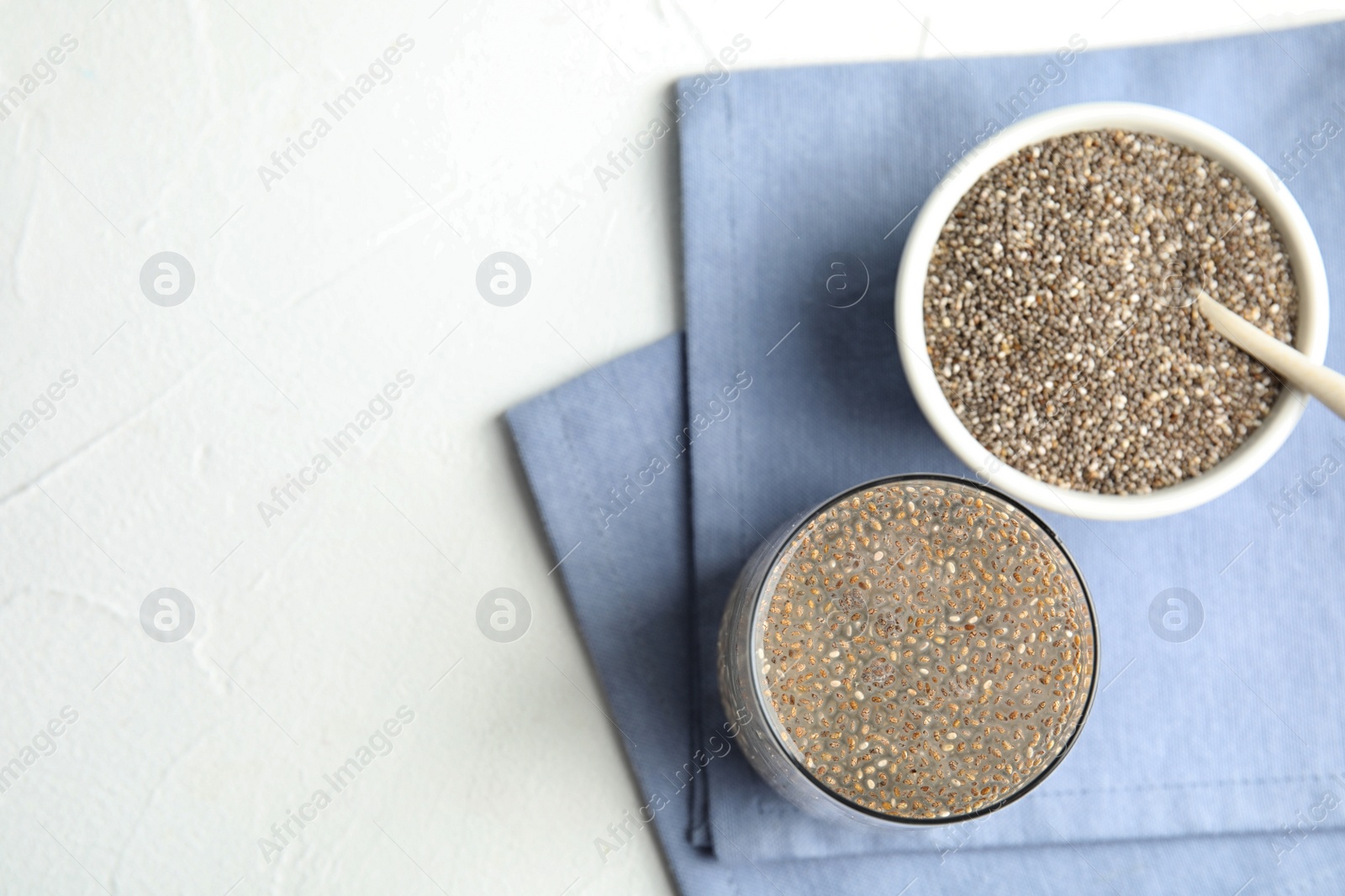 Photo of Flat lay composition with glass of water and chia seeds on white background, space for text