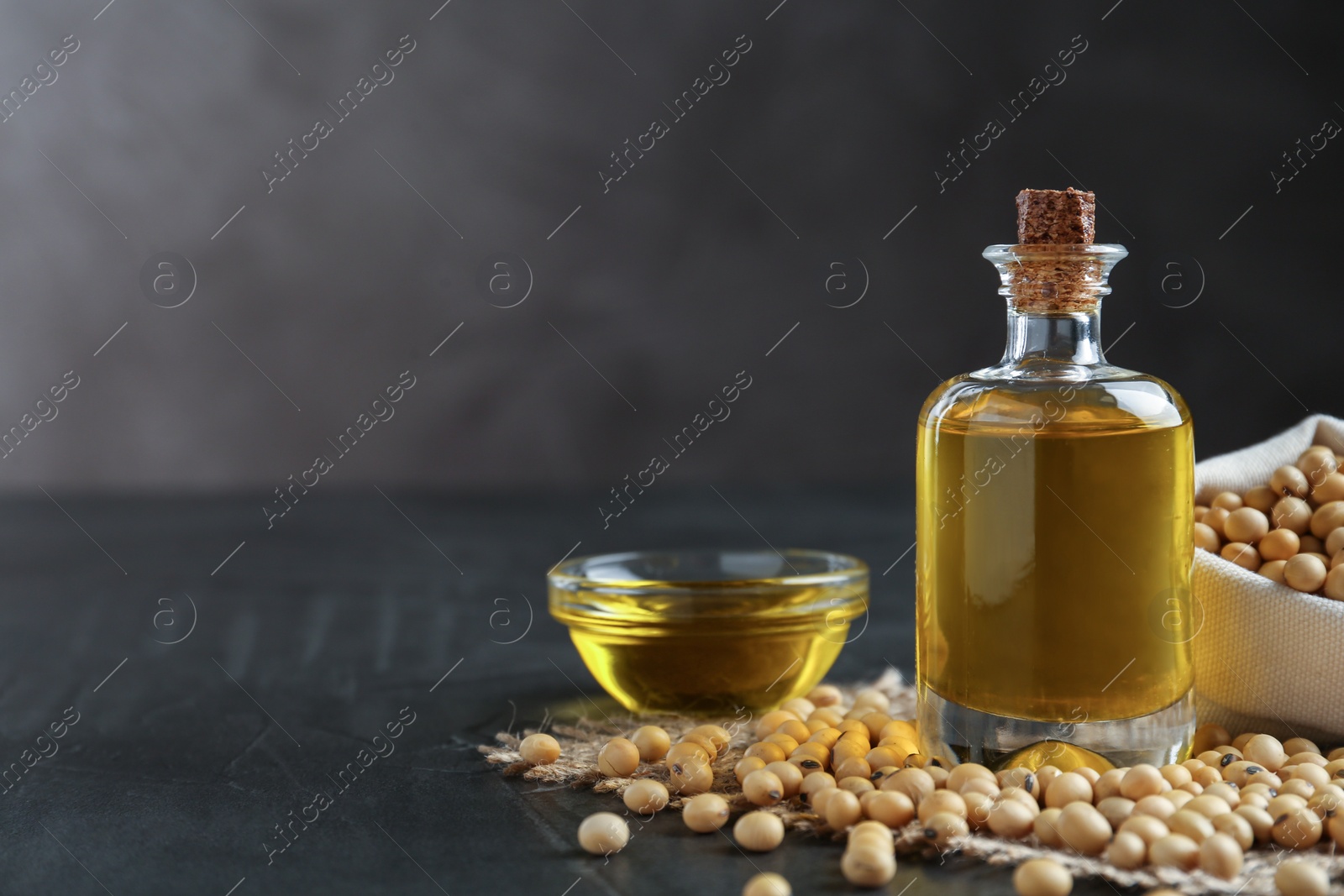 Photo of Composition with soybean oil on grey table. Space for text