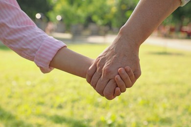 Mature woman with her little granddaughter in park, closeup