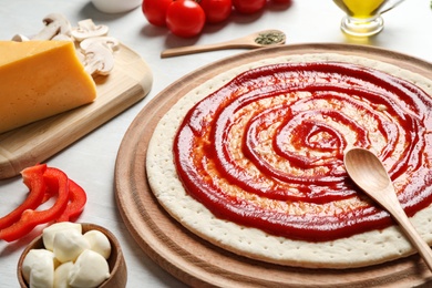 Composition with pizza crust and ingredients on table, closeup