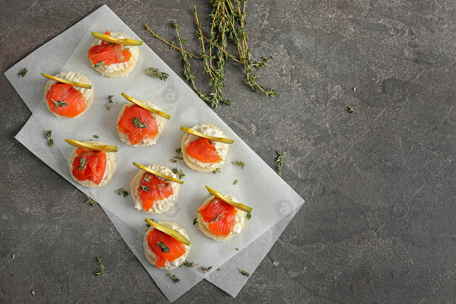 Photo of Tasty sandwiches with fresh sliced salmon fillet and avocado on table, top view