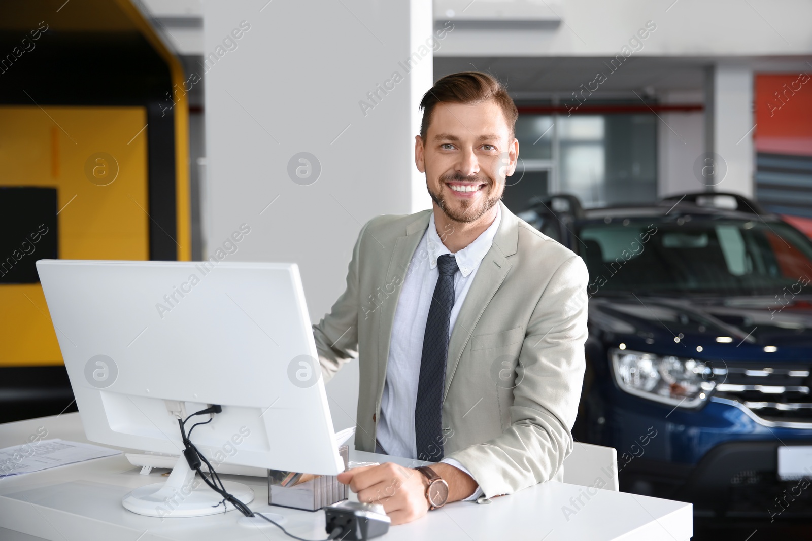 Photo of Salesman working in modern car dealership. Buying new auto