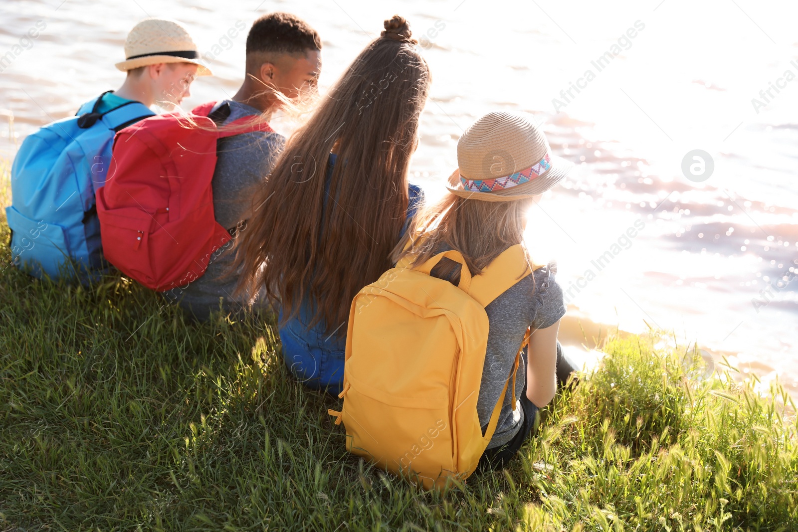 Photo of Group of children with backpacks on coast. Summer camp