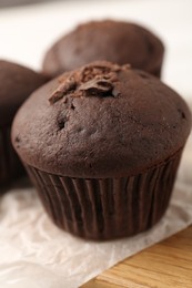 Photo of Delicious cupcake with chocolate crumbles on wooden board, closeup
