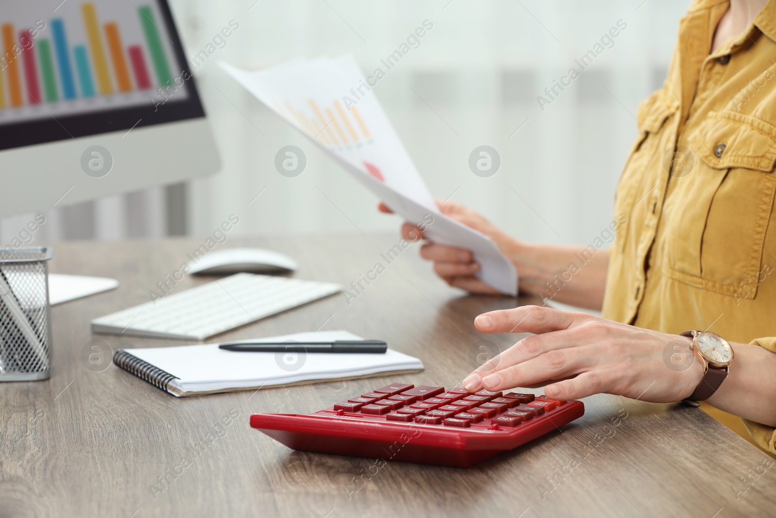 Photo of Professional accountant using calculator at wooden desk in office, closeup