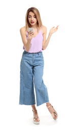 Young woman using phone on white background