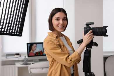 Photo of Professional photographer working with camera in modern photo studio