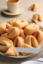 Tasty fortune cookies and paper with prediction on wooden table, closeup. Space for text