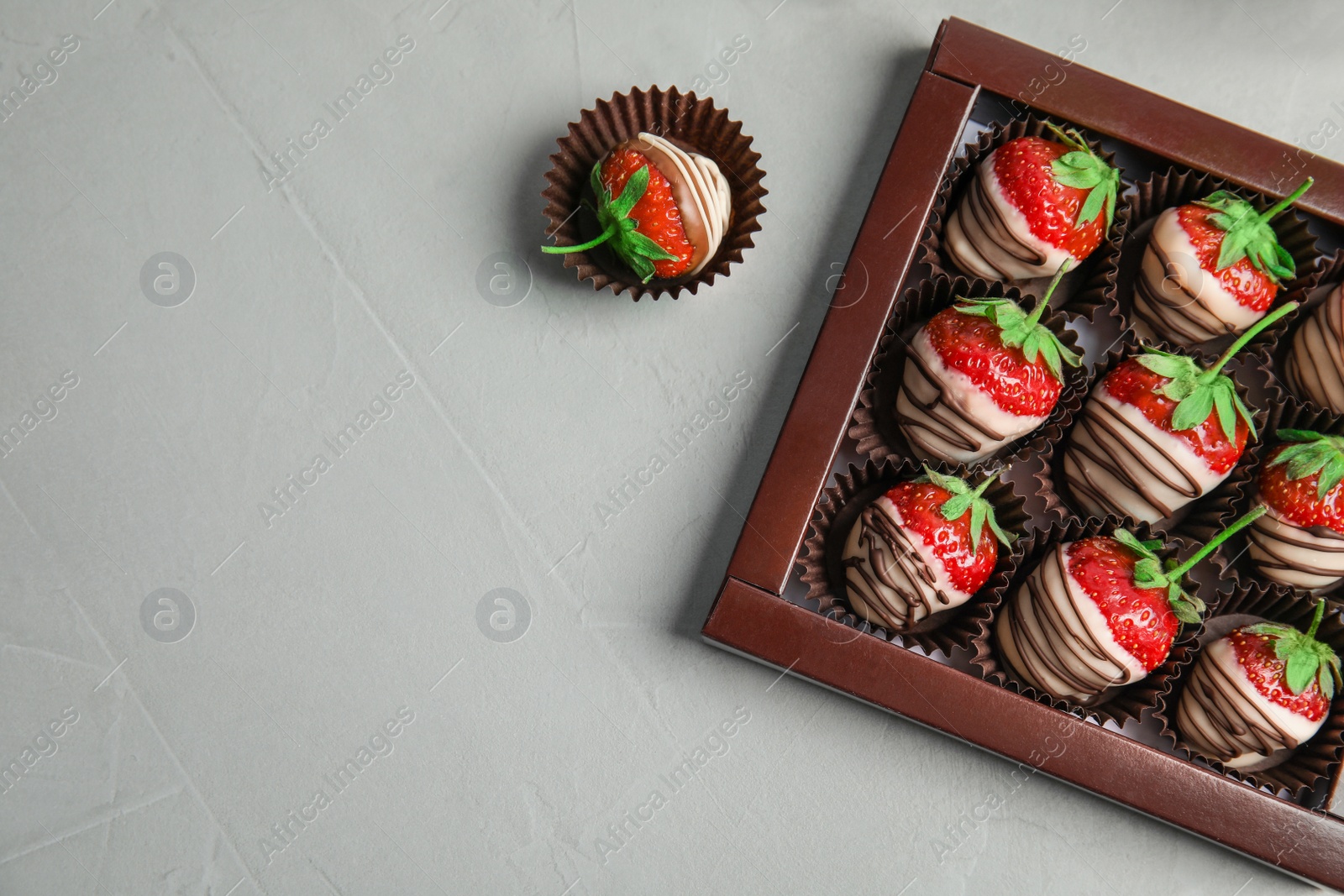 Photo of Flat lay composition with chocolate covered strawberries on grey background