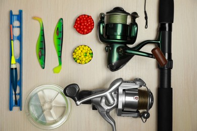 Fishing tackle on wooden background, flat lay