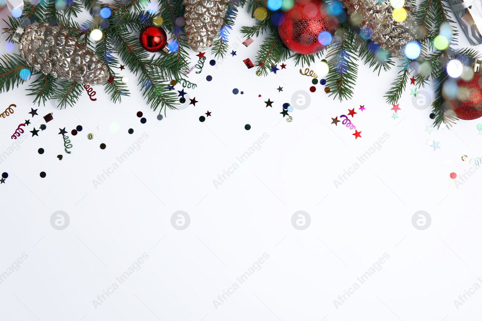 Photo of Christmas greeting card with space for text. Flat lay composition of fir tree branches and festive decor on white background