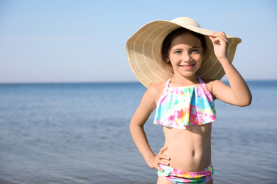Photo of Cute little child with straw hat on sunny day. Beach holiday