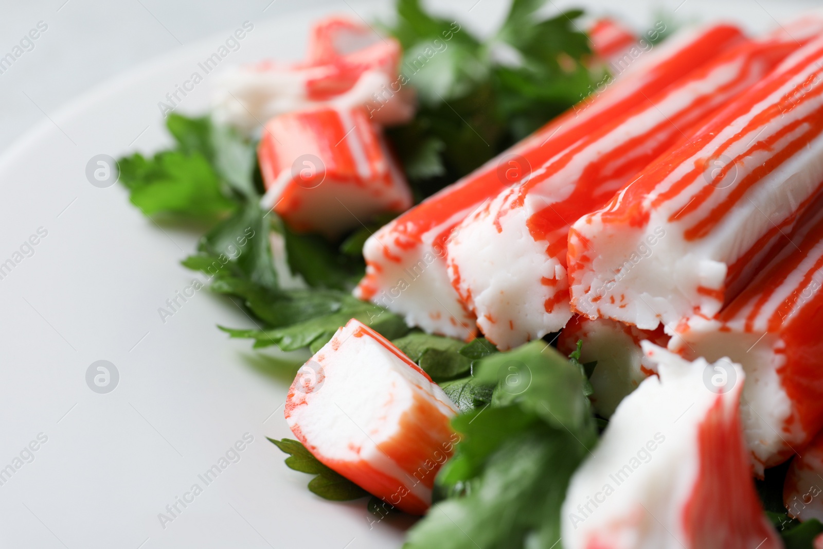 Photo of Crab sticks and parsley on plate, closeup