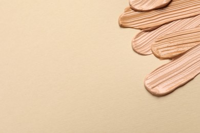 Photo of Samples of skin foundation on beige background. Space for text