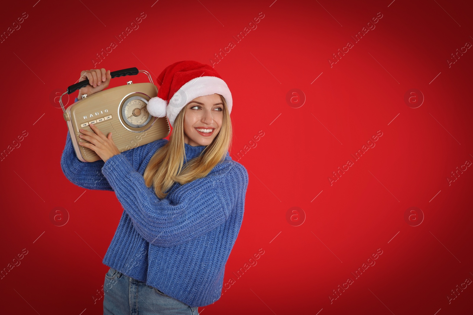 Photo of Happy woman with vintage radio on red background, space for text. Christmas music