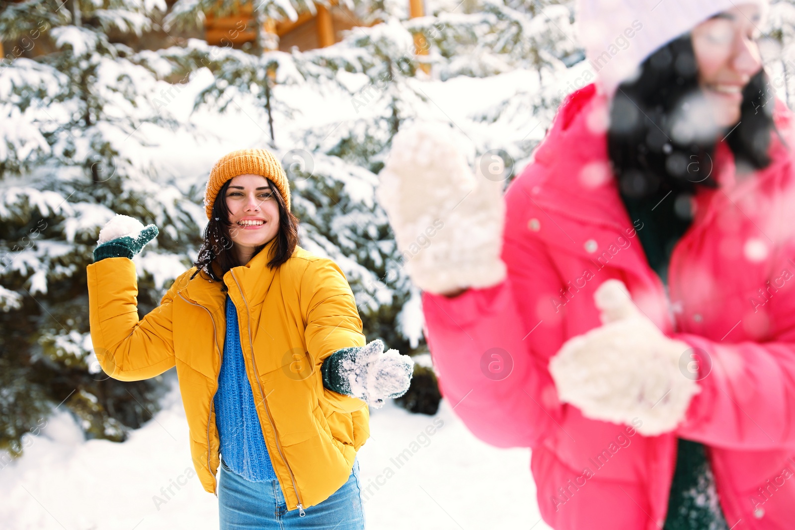 Photo of Happy friends playing snowballs outdoors. Winter vacation