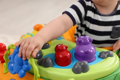 Photo of Little baby playing with toy walker, closeup