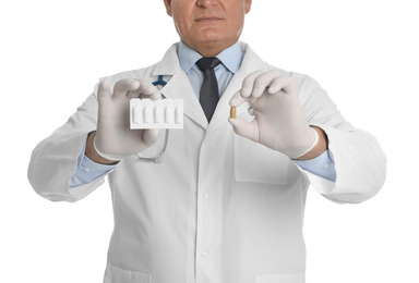 Doctor holding suppositories for hemorrhoid treatment on white background, closeup
