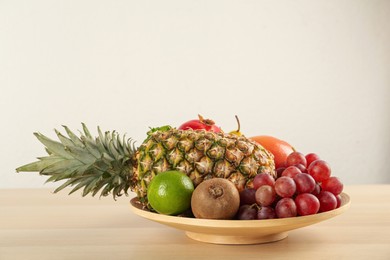 Photo of Fresh ripe fruits on wooden table against white background