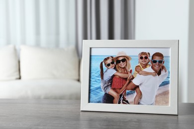 Frame with family photo on wooden table indoors, space for text