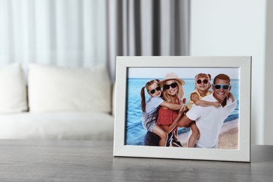 Photo of Frame with family photo on wooden table indoors, space for text