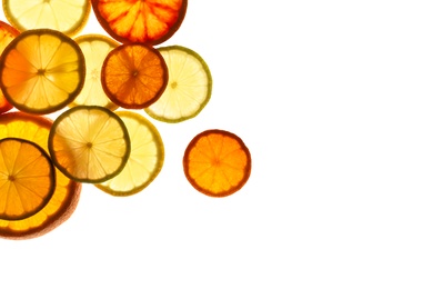 Illuminated slices of citrus fruits on white background, top view