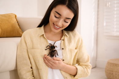 Photo of Woman with striped knee tarantula at home. Exotic pet