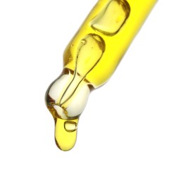 Photo of Dripping yellow facial serum from pipette on white background, closeup