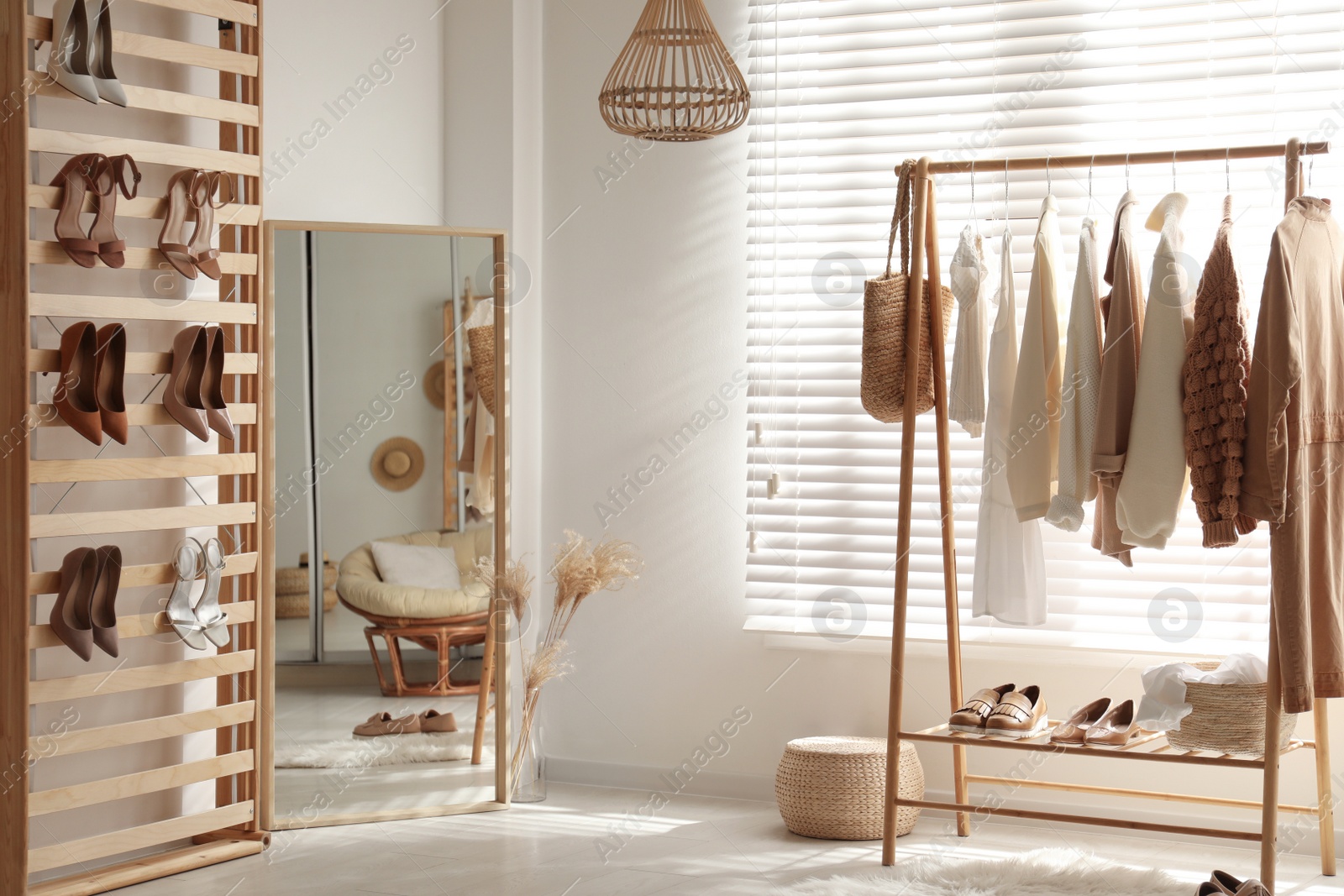 Photo of Modern dressing room interior with racks of stylish women's clothes and shoes