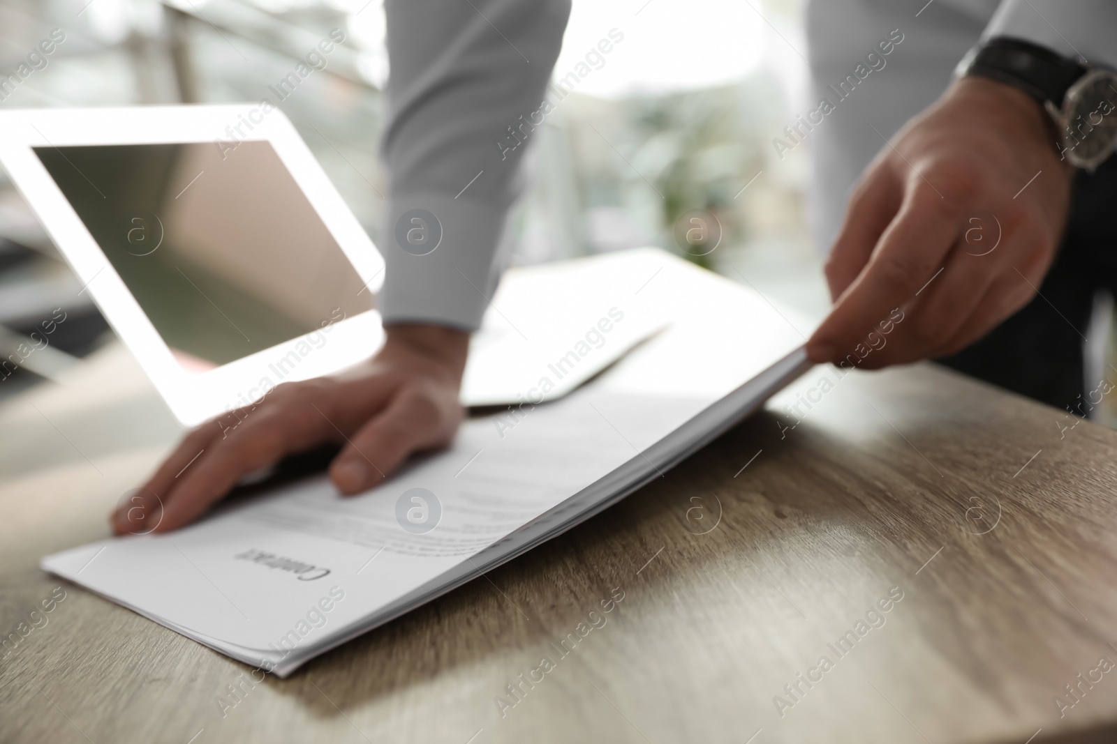 Photo of Businessman working with documents at wooden desk in office, closeup