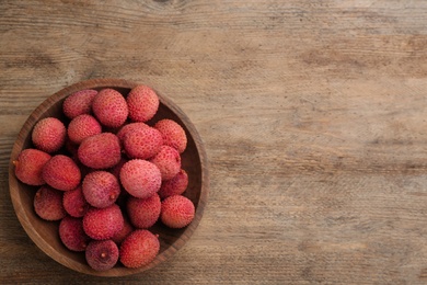 Fresh ripe lychees on wooden table, top view. Space for text