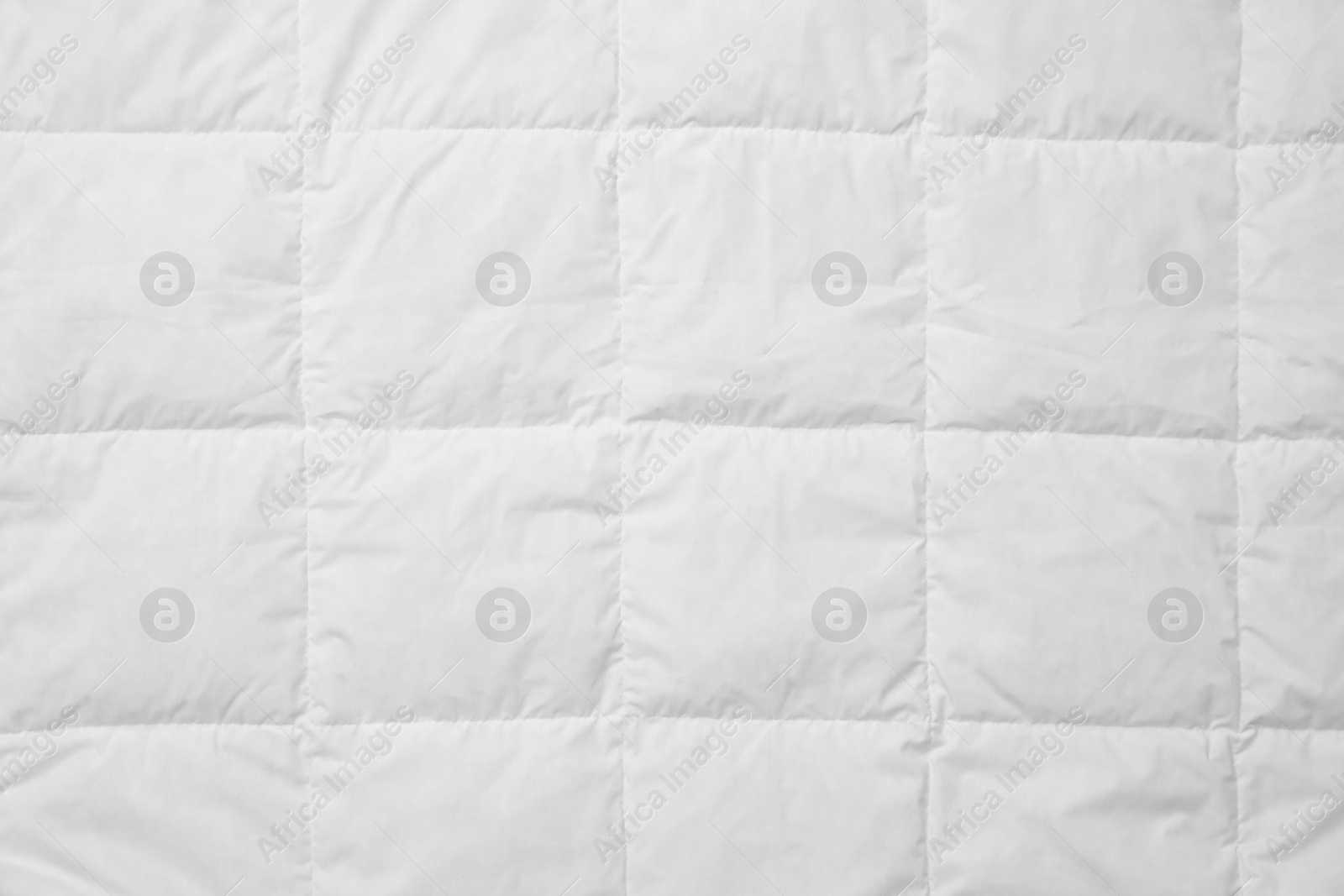 Photo of Soft quilted blanket as background, top view